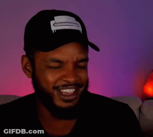 A Man With A Beard Is Wearing A Hat And Making A Funny Face With His Eyes Closed . GIF