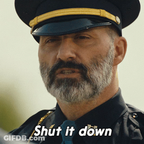 A Man With A Beard Is Wearing A Hat And Tie And Has The Words Shut It Down On His Face GIF
