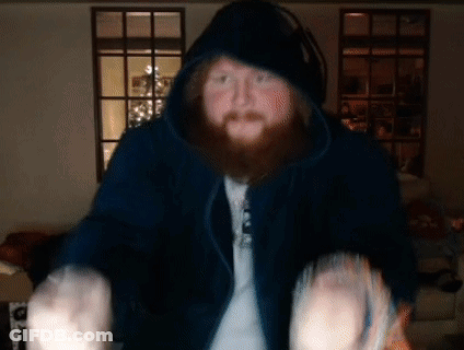A Man With A Beard Is Wearing A Hoodie And Headphones GIF