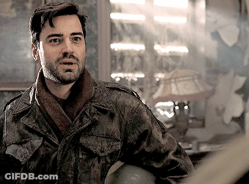 A Man With A Beard Is Wearing A Jacket And Scarf And Holding A Helmet GIF