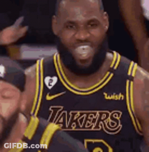 A Man With A Beard Is Wearing A Lakers Jersey And Smiling . GIF