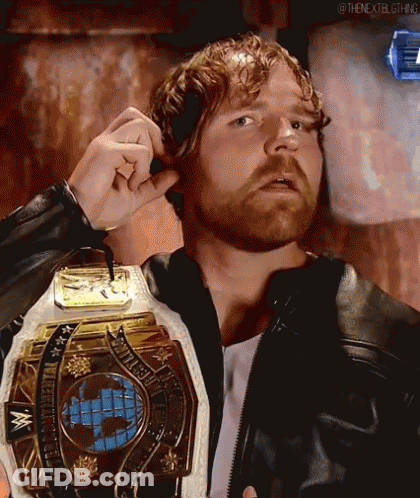A Man With A Beard Is Wearing A Leather Jacket And Holding A Wrestling Championship Belt . GIF