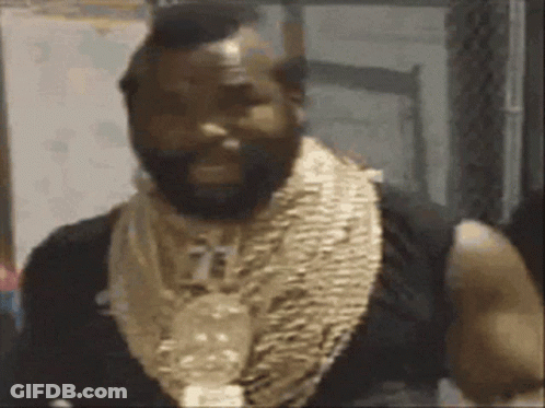 A Man With A Beard Is Wearing A Lot Of Gold Necklaces Around His Neck . GIF