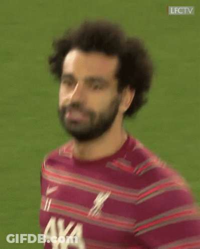 A Man With A Beard Is Wearing A Maroon Striped Shirt With A Logo For Axa On It . GIF
