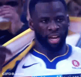 A Man With A Beard Is Wearing A Nike Jersey While Watching A Game . GIF