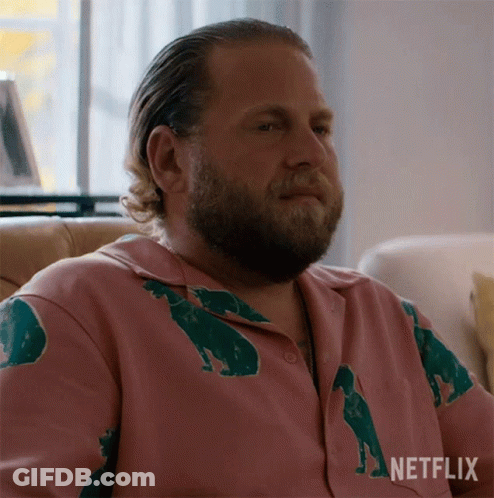A Man With A Beard Is Wearing A Pink Shirt With Bears On It GIF