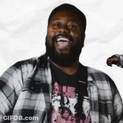 A Man With A Beard Is Wearing A Plaid Shirt And A T-Shirt That Says Rie GIF
