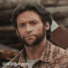 A Man With A Beard Is Wearing A Plaid Shirt And Carrying A Brown Wallet GIF