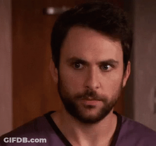 A Man With A Beard Is Wearing A Purple Scrub Top And The Word Rape Is Written On His Face . GIF