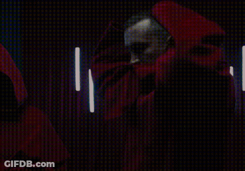 A Man With A Beard Is Wearing A Red Cape With A Hood GIF