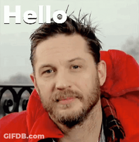 A Man With A Beard Is Wearing A Red Jacket And Smiling . GIF