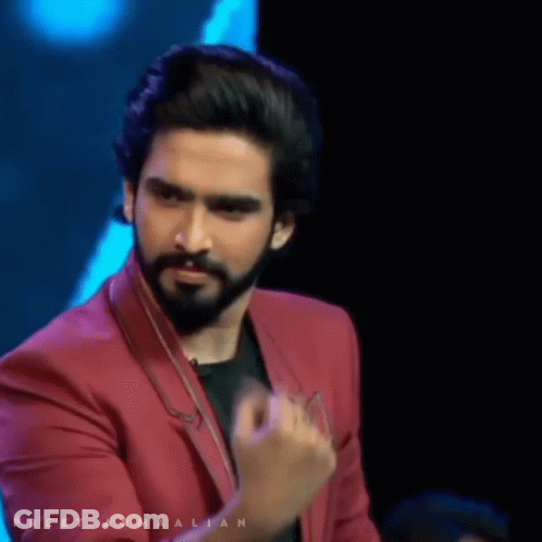 A Man With A Beard Is Wearing A Red Jacket With The Name Preet Armaalian Written On It GIF