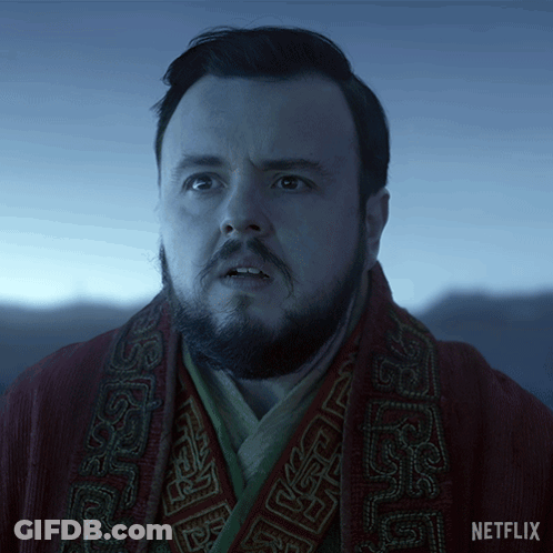 A Man With A Beard Is Wearing A Red Robe With A Netflix Logo On The Bottom GIF