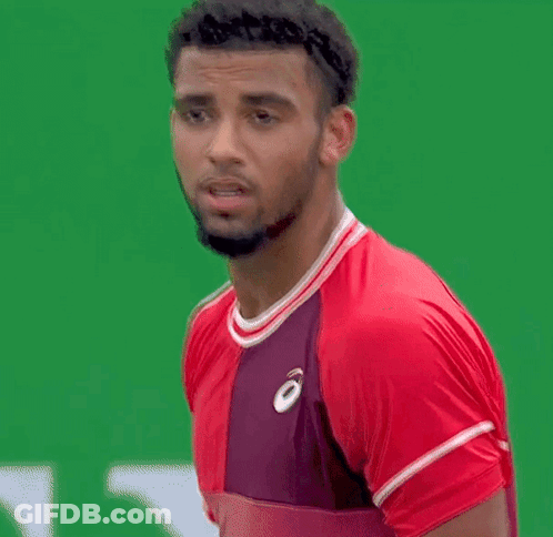 A Man With A Beard Is Wearing A Red Shirt And A Purple Shirt . GIF