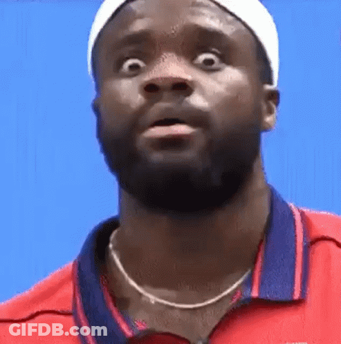 A Man With A Beard Is Wearing A Red Shirt And A White Headband And Making A Funny Face . GIF