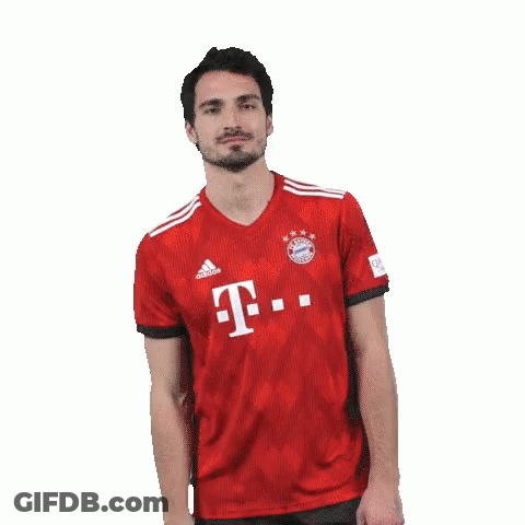 A Man With A Beard Is Wearing A Red T-Mobile Jersey And Making A Funny Face . GIF