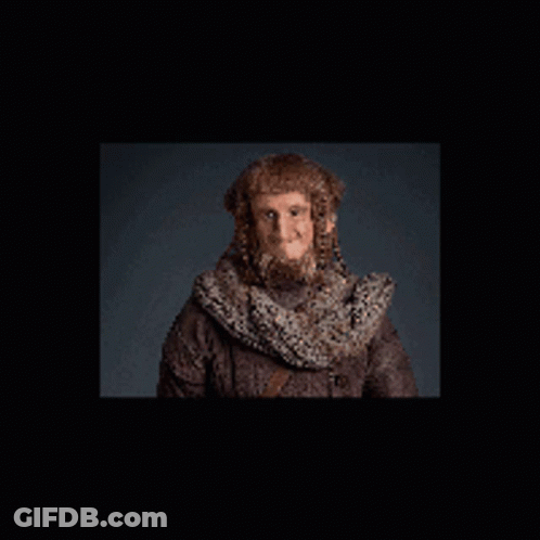 A Man With A Beard Is Wearing A Scarf And A Hat GIF