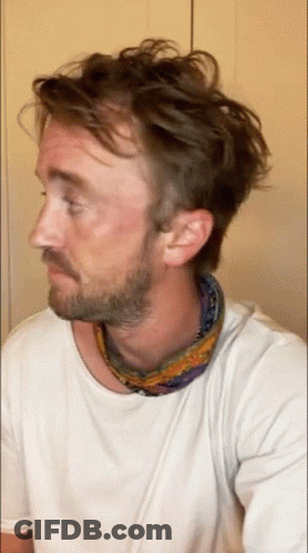 A Man With A Beard Is Wearing A Scarf Around His Neck GIF