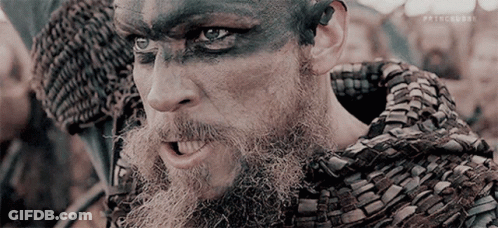 A Man With A Beard Is Wearing A Scarf Around His Neck . GIF