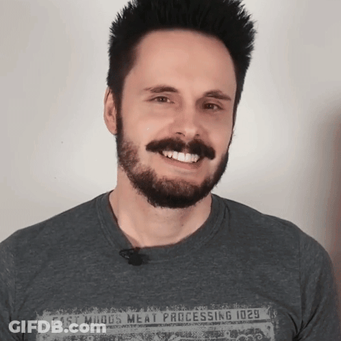 A Man With A Beard Is Wearing A Shirt That Says Meat Processing GIF