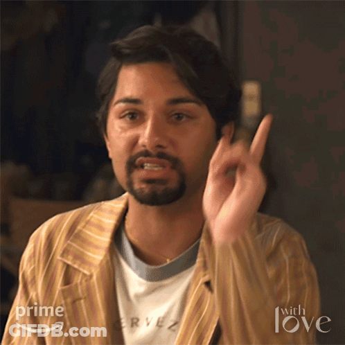 A Man With A Beard Is Wearing A Striped Jacket And A T-Shirt That Says Rye On It . GIF