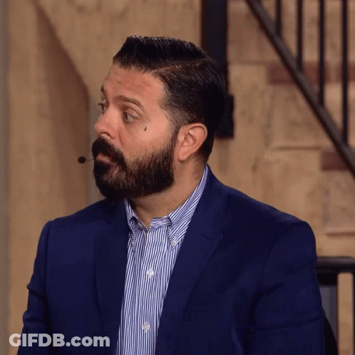 A Man With A Beard Is Wearing A Suit And Striped Shirt GIF