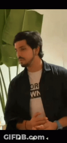 A Man With A Beard Is Wearing A T-Shirt That Says " Or " On It . GIF