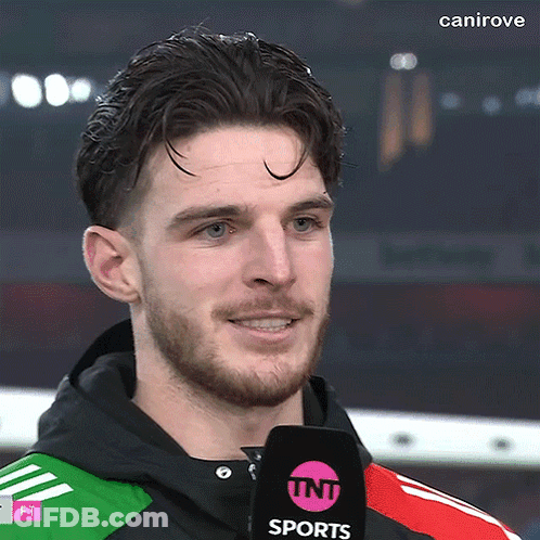 A Man With A Beard Is Wearing A Tnt Sports Microphone GIF