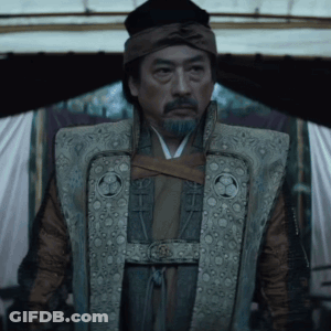A Man With A Beard Is Wearing A Vest With A Circle On The Front GIF
