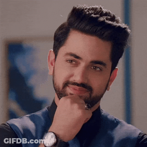 A Man With A Beard Is Wearing A Watch And A Ring On His Finger . GIF