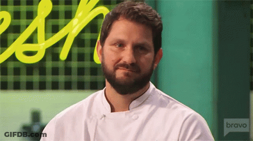 A Man With A Beard Is Wearing A White Chef 'S Jacket With The Word Bravo On The Front GIF