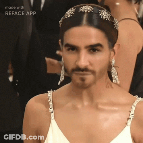 A Man With A Beard Is Wearing A White Dress And Earrings Made By Reface App GIF