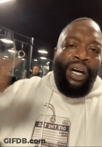 A Man With A Beard Is Wearing A White Hoodie With A Tag That Says Dt 3Ht 370 On It GIF