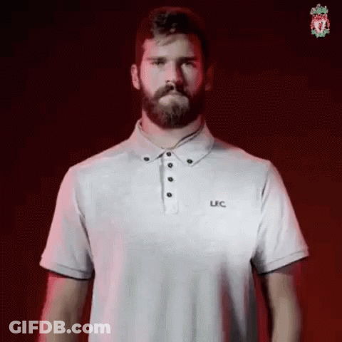 A Man With A Beard Is Wearing A White Polo Shirt And Standing In Front Of A Red Background . GIF