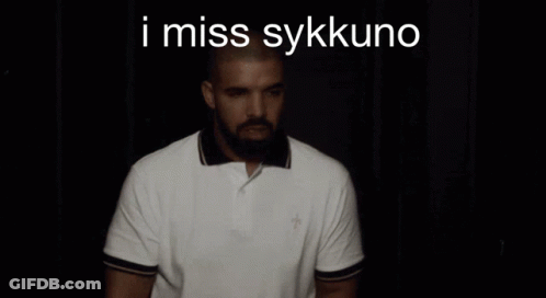 A Man With A Beard Is Wearing A White Polo Shirt With The Words I Miss Sykkuno On The Bottom GIF