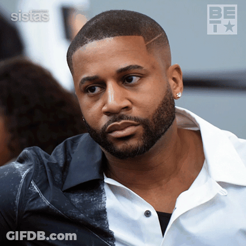 A Man With A Beard Is Wearing A White Shirt And A Black Shirt GIF