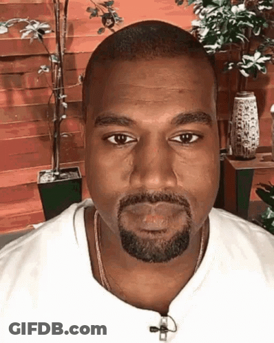 A Man With A Beard Is Wearing A White Shirt And A Gold Chain Around His Neck GIF