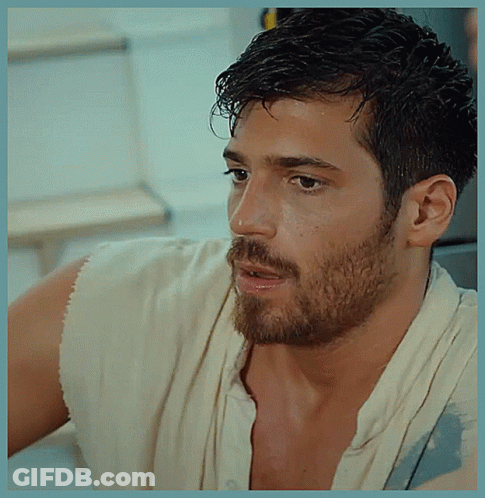 A Man With A Beard Is Wearing A White Shirt And A White Towel Around His Neck GIF