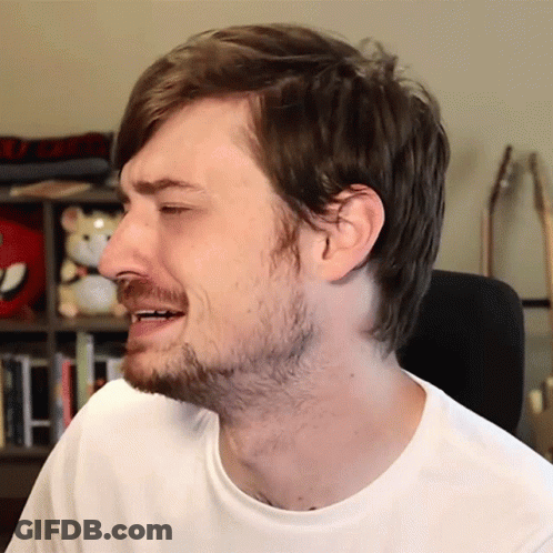 A Man With A Beard Is Wearing A White Shirt And Making A Face GIF