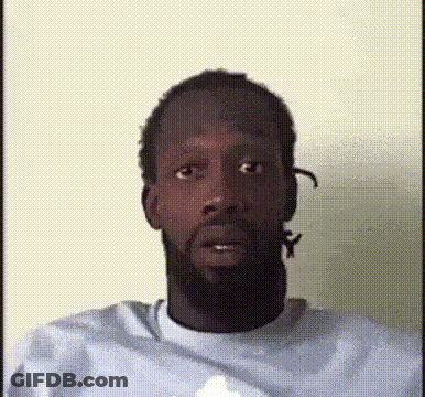 A Man With A Beard Is Wearing A White Shirt And Making A Funny Face GIF