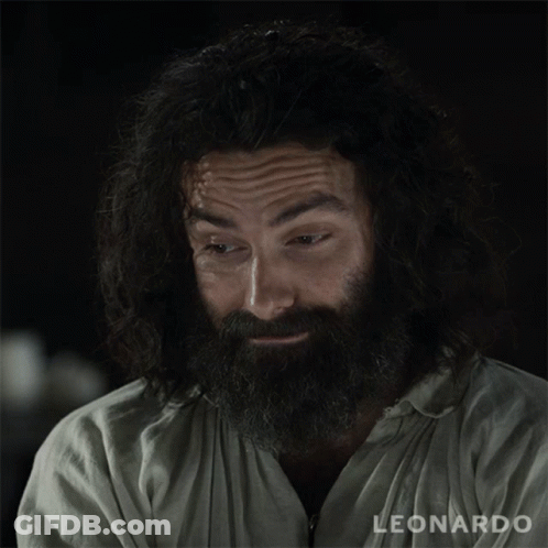 A Man With A Beard Is Wearing A White Shirt That Says Leonardo GIF