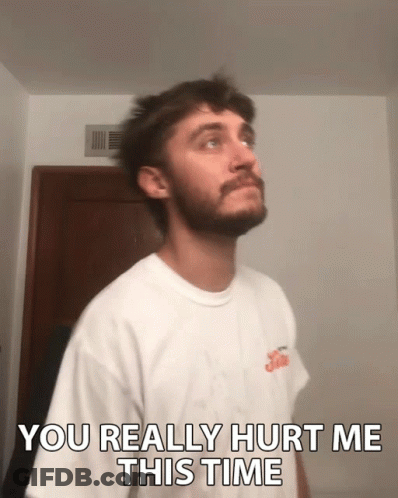 A Man With A Beard Is Wearing A White Shirt That Says ' You Really Hurt Me This Time ' GIF