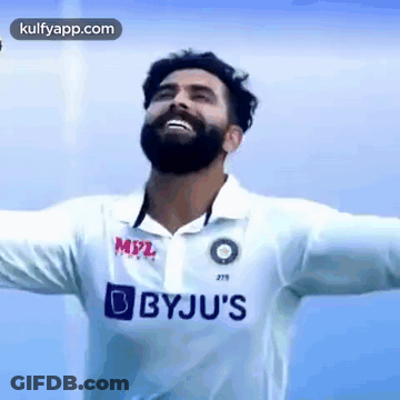 A Man With A Beard Is Wearing A White Shirt With Bbyju 'S Written On It . GIF