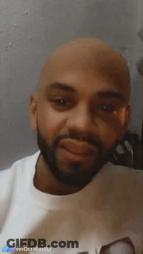 A Man With A Beard Is Wearing A White Shirt With The Word Momento On It GIF