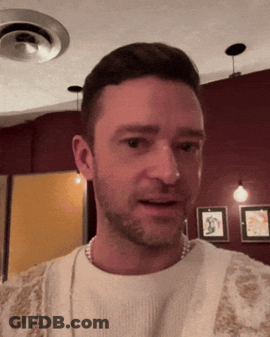 A Man With A Beard Is Wearing A White Sweater And A Pearl Necklace GIF