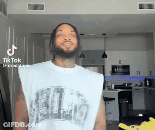 A Man With A Beard Is Wearing A White Tank Top That Says ' Chicago ' On It GIF