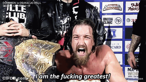 A Man With A Beard Is Wearing A Wrestling Belt And Says I Am The Fucking Greatest GIF