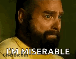 A Man With A Beard Is Wearing A Yellow Shirt And Saying I 'M Miserable . GIF