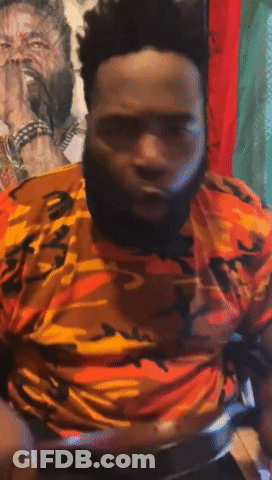 A Man With A Beard Is Wearing An Orange And Yellow Camouflage Shirt GIF