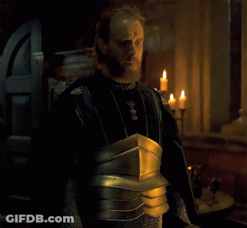 A Man With A Beard Is Wearing Armor And Standing In Front Of A Window With Candles GIF